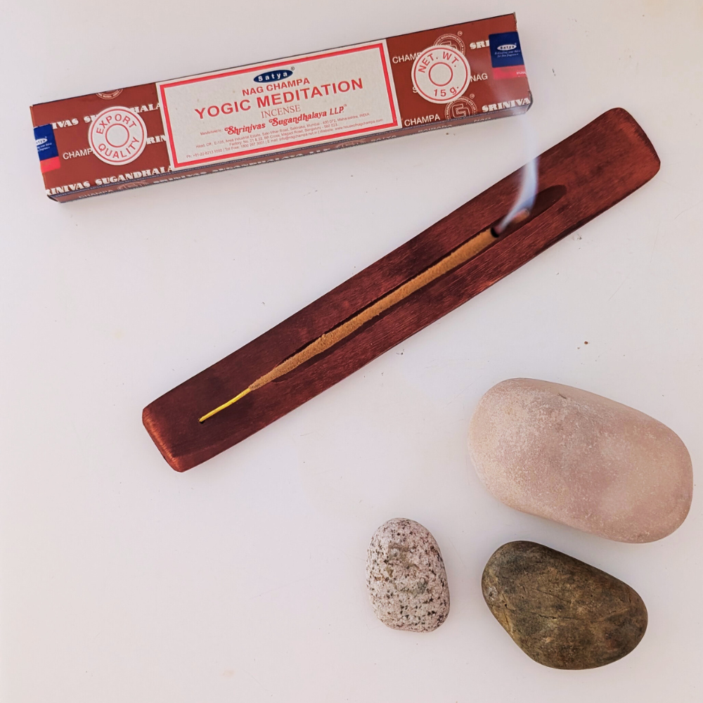 burning a stick on a hand-crafted wooden INCENse holder burner , yogion meditation satya incense sticks