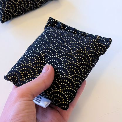 hand holding a Black and Gold scale Lavender sachet
