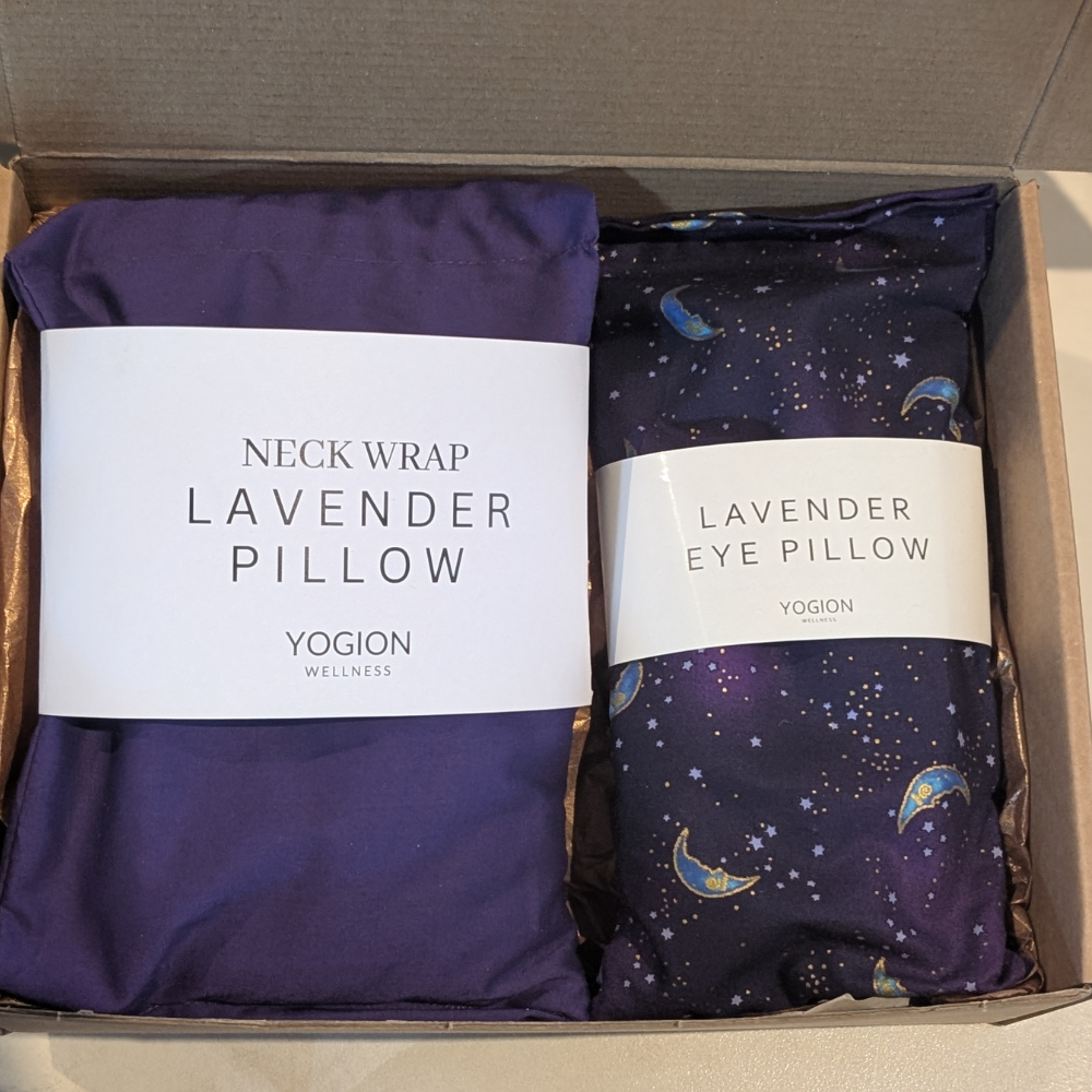Two lavender pillows, one neck wrap and one purple moon pattern fabric eye pillow, in a box for gift set by yogion wellness