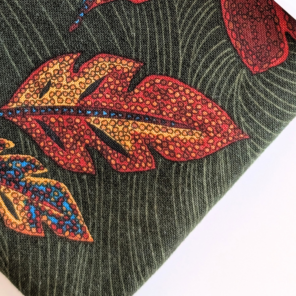 Close-up of a fabric with print of leaves on a green background
