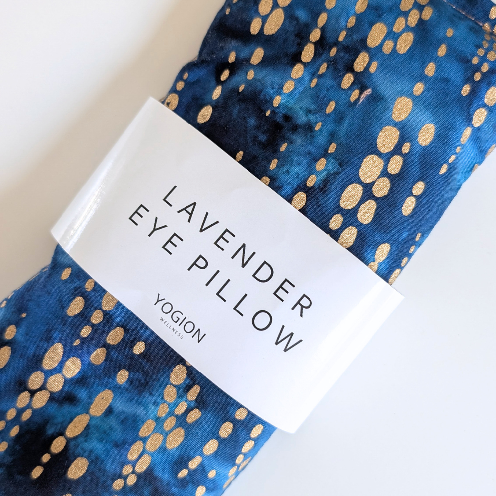 Lavender eye pillow with gold speckles and a white label on a light background by yogion wellness