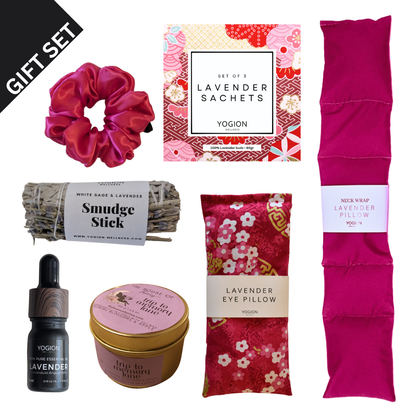 Gift set with lavender-themed products including a scrunchie, sachets,eye pillow, neck wraps, soy wax candle , sage stick, smudge stick, essential oil on a white background all handmade by yogion wellness