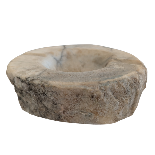 A circular stone candle holder or dish made of natural stone with a textured, rough outer edge and a smooth, recessed center, shown on a plain white background. for smudging and rituals