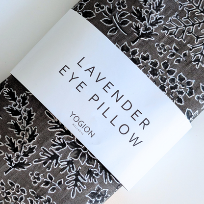 Lavender eye pillow with floral pattern and 'Yogion Wellness' branding on a white background
