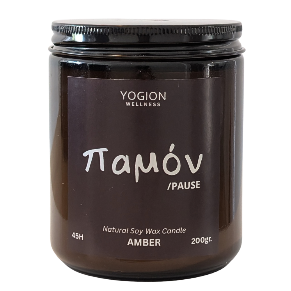 Yogion Wellness amber soy wax candle in a dark amber glass jar with a black screw-on lid and a black label featuring white text Παμόν