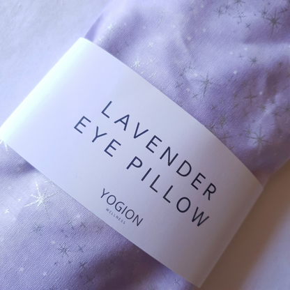 Lavender eye pillow with a label on a light purple fabric background