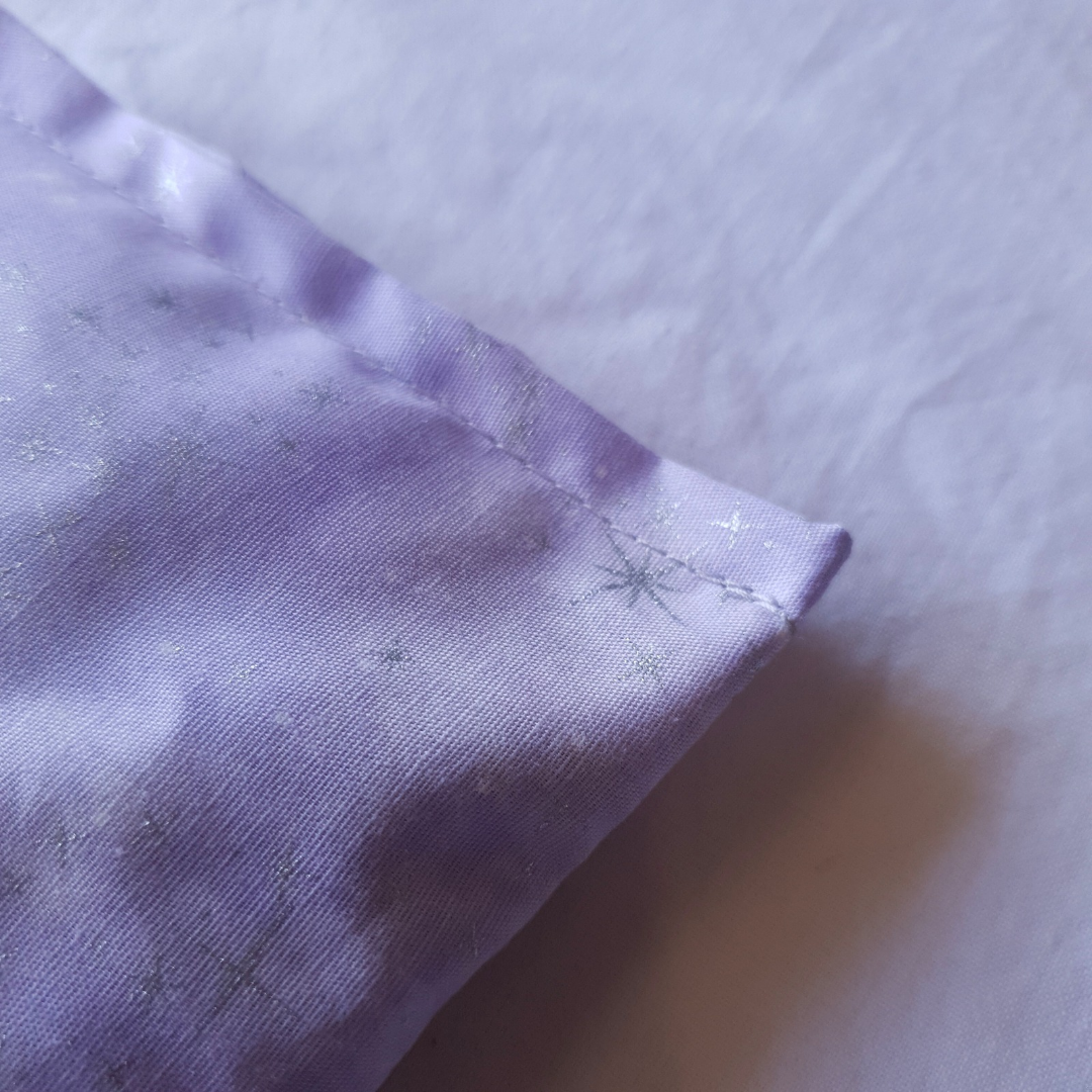 Close-up of a purple fabric corner on a light gray background