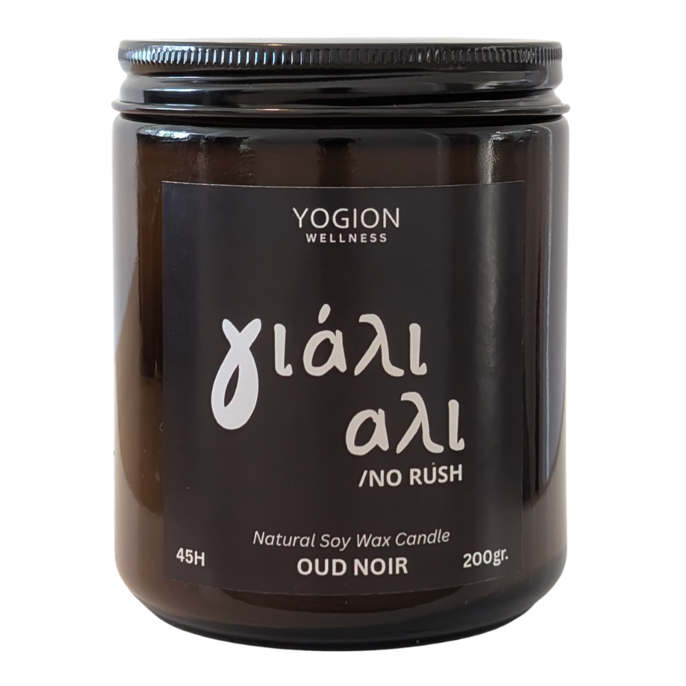 A 200g jar of Yogion Wellness 'Oud Noir' natural soy wax candle, featuring a black glass container, black lid, and a black label with white text with yiali yiali meaning no rush in greek cypriot dialect